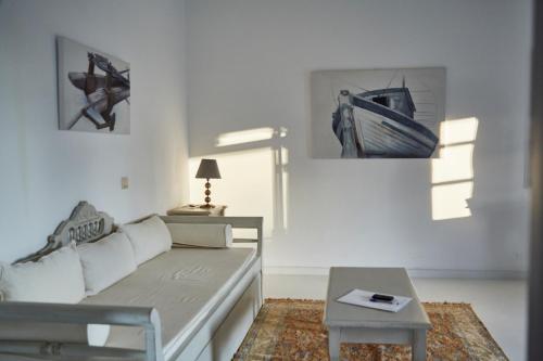 a white living room with a couch and a table at 9 Muses Exclusive Apartments in Grikos