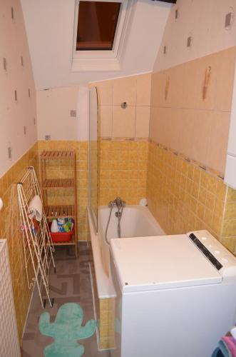 La petite salle de bains est pourvue d'une baignoire et de toilettes. dans l'établissement Appartement vue mer Granville, à Granville