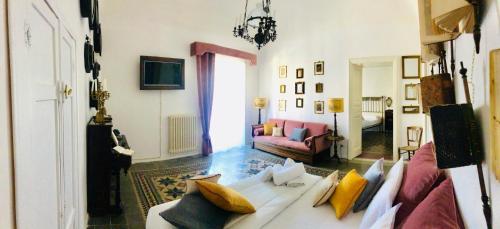 a living room with a white couch with pillows at La casa sulla piazza (Historic apartment) in Enna