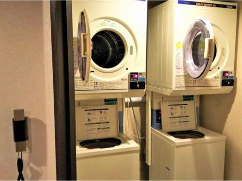 two washing machines and a washer and dryer in a room at R Hotels Inn Hokkaido Asahikawa in Asahikawa