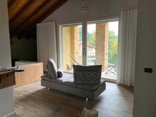a living room with a couch and a large window at Azienda Agrituristica Calronche in Refrontolo