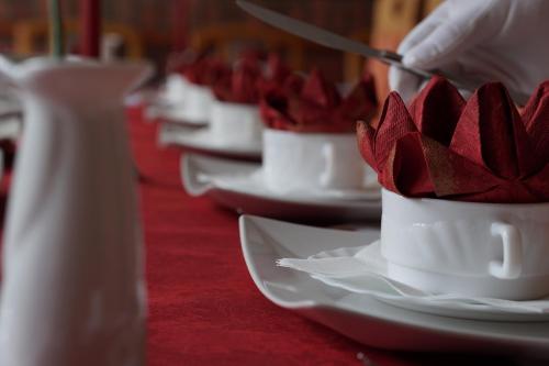 a row of white cups with red flowers in them at Pension Luisenhof in Tangermünde