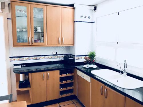 a kitchen with wooden cabinets and a sink at Casa AuroraBikinis in Fuengirola