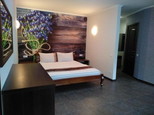 - une chambre avec un lit orné d'un vase de fleurs sur le mur dans l'établissement Comfortable apartment in the center, à Tchernihiv