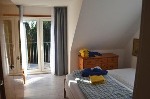 a bedroom with a bed with blue and yellow towels on it at Meerblick in Nieblum