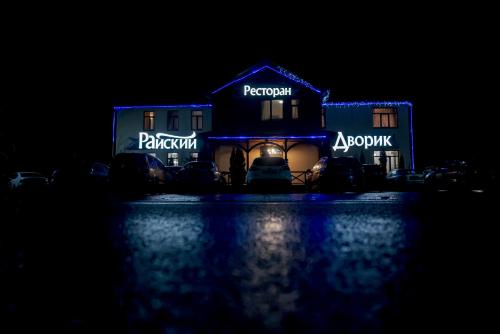 a house lit up in blue at night at Райский Дворик in Pogreby