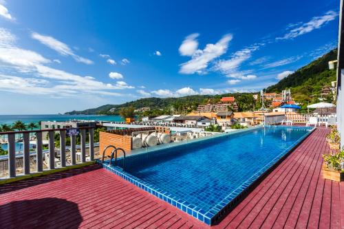 a swimming pool on a balcony with the ocean in the background at 7Q Patong Beach Hotel in Patong Beach