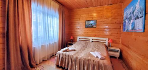 バコヴェルにあるZakhid Cottage Complexの木製の部屋にベッド1台が備わるベッドルーム1室があります。