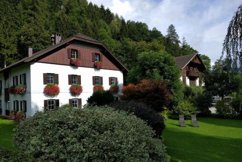 a white house with flower boxes on the windows at Jörgleggerhof in Nikolsdorf