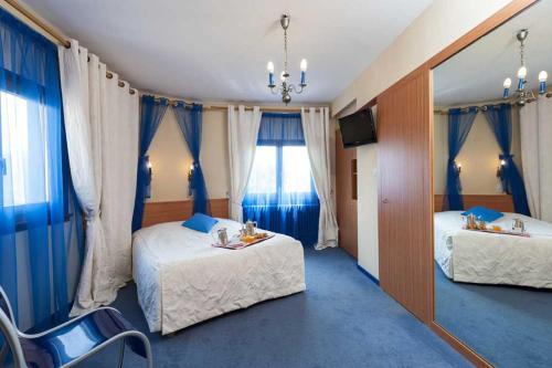 穆巴赫索蒙斯特Hotel Restaurant Perle Des Vosges的有两张床和一台电视的酒店房间