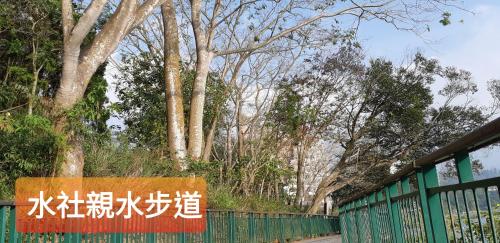 a sign on a fence in front of trees at Ze Hu B&B in Yuchi