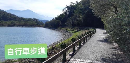 a road next to a body of water with a sign at Ze Hu B&B in Yuchi