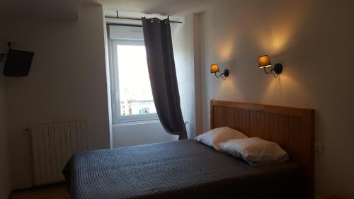 a bedroom with a bed and a window at HOTEL DE FRANCE in Maubourguet