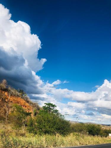 a blue sky with clouds above a road at Casa Verde na Chapada Diamantina in Palmeiras
