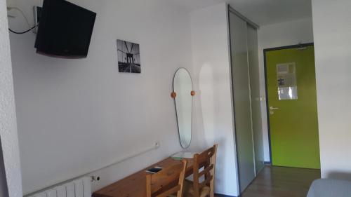 a room with a table and a mirror and a door at HOTEL DE FRANCE in Maubourguet