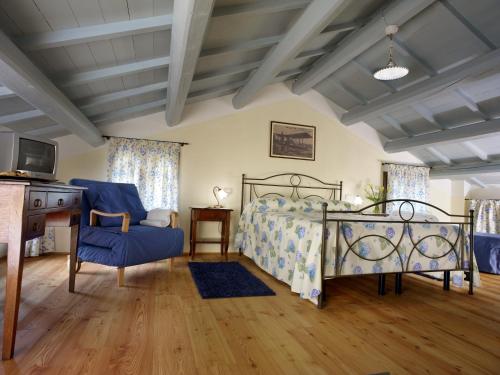 una camera con letto, sedia e TV di Tenuta Le Risare a Campo San Martino