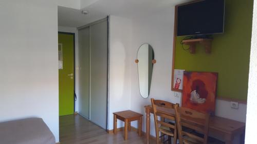 a dining room with a table and a mirror on the wall at HOTEL DE FRANCE in Maubourguet