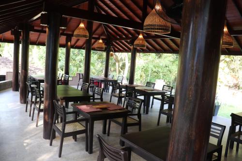 a restaurant with many tables and chairs and lights at Goyambokka Guesthouse in Tangalle