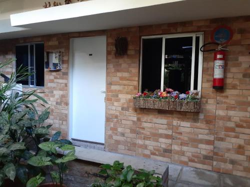 a house with a window with flowers in a window box at Hotel Pousada Casuarinas in Recife