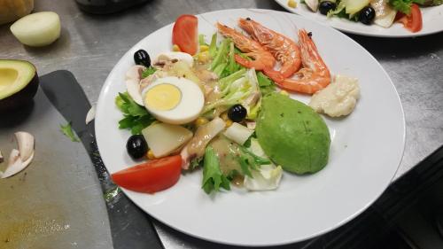 a white plate of food with an egg and vegetables at HOTEL DE FRANCE in Maubourguet