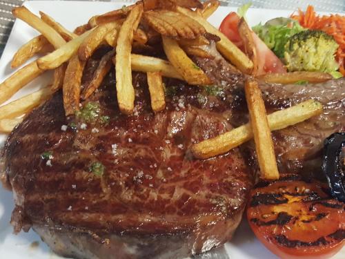 a steak with french fries and vegetables on a plate at HOTEL DE FRANCE in Maubourguet