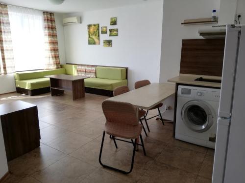 a living room with a table and a washing machine at Apartamenti Zhelezovi in Pomorie