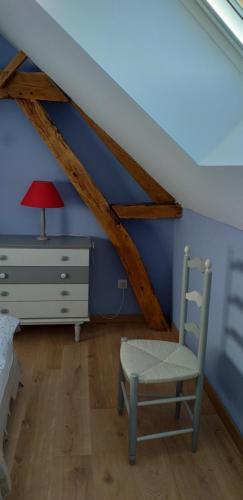 a bedroom with a bed and a chair and a dresser at Le rucher in Lez-Fontaine
