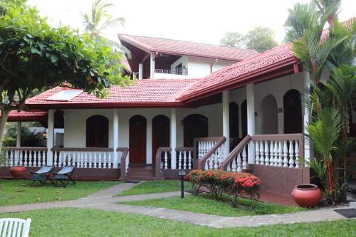 a small white house with a red roof at Goyambokka Guesthouse in Tangalle