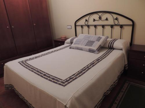 a bedroom with a bed with a black headboard at Casa Rural El Chorritero in Ovejuela