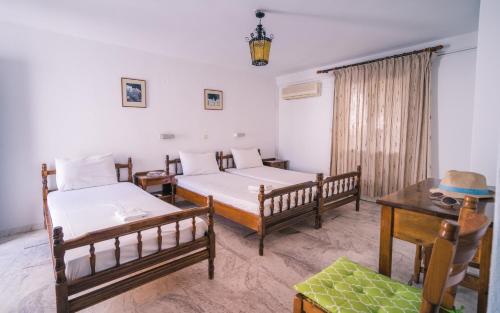 a room with two beds and a table and a desk at Podotas Group in Kamarai
