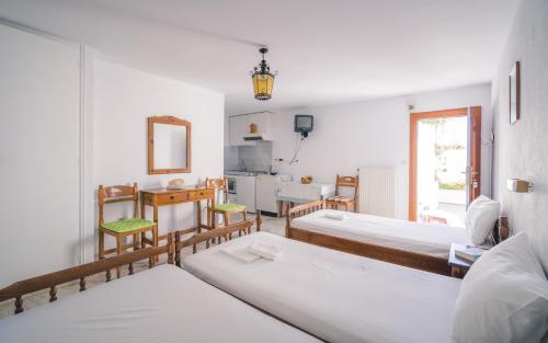 a room with three beds and a kitchen in it at Podotas Group in Kamares