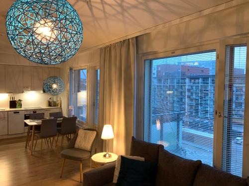 uma sala de estar com uma grande janela e uma cozinha em The Harbour Apartments em Jyväskylä