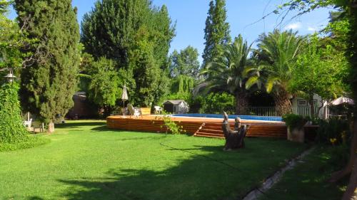 a swimming pool in a yard with trees and grass at Quinta Ugarte in Ciudad Lujan de Cuyo