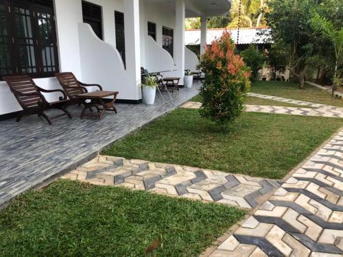 a patio with chairs and a yard with grass at skyresort in Tangalle