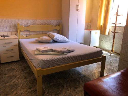 um quarto com uma cama com duas toalhas em Pousada Beira Mar em Rio das Ostras