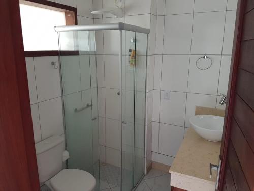 uma casa de banho com um chuveiro, um WC e um lavatório. em Flat no Condomínio Brisas do Amor em Pipa