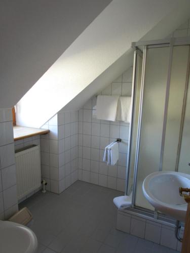 een badkamer op zolder met een wastafel en een douche bij Pension Eva in Neuhaus am Inn