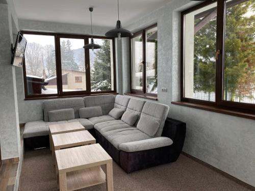 a living room with a couch and some windows at Penzion Panorama in Liptovský Mikuláš