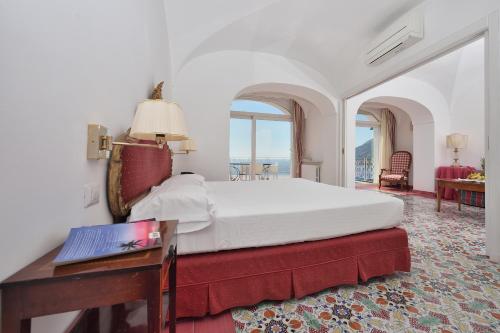 a bedroom with a bed and a desk with a laptop at Hotel Luna Convento in Amalfi