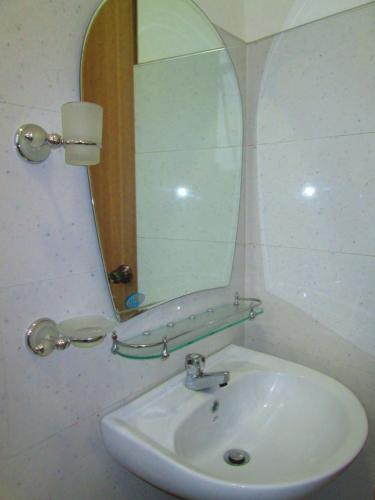 a bathroom with a sink and a mirror at Kandyan Sweet Villa in Kandy