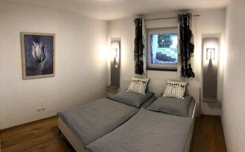 - une chambre avec 2 lits et une fenêtre dans l'établissement Ferienwohnung Gasser, à Ebringen