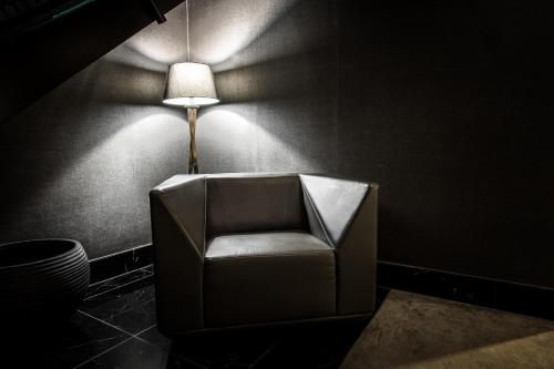 a chair in a dark room with a lamp at Black Hotels Köln in Cologne