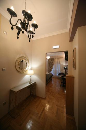 ein Wohnzimmer mit einem Kronleuchter und einem Spiegel in der Unterkunft Denise Luxury Apartment-Centre of Athens,Kolonaki in Athen
