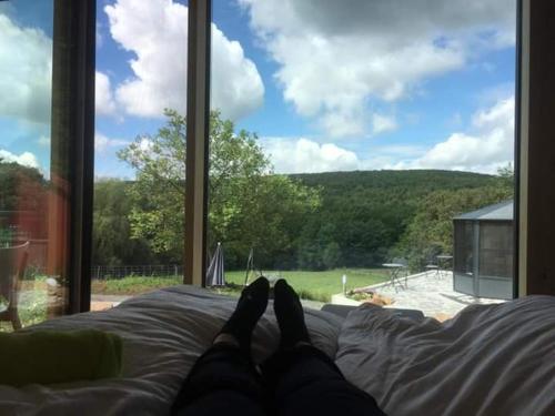 a person laying on a bed looking out a window at kleinHOTEL Steinau-Rabenstein GbR in Steinau an der Straße