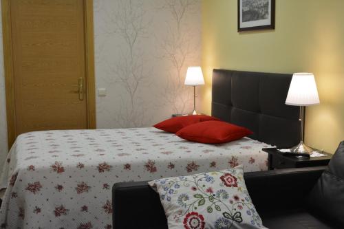 a bedroom with a large bed with red pillows at Arouca Passadiços Alojamento in Arouca