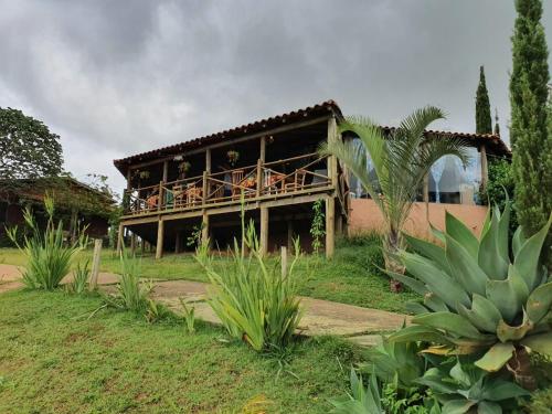 a house with a balcony with people on it at Camping e Chalé Estação Rural in Bragança Paulista