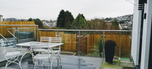 a patio with a table and chairs on a deck at Boleyn house in Bodmin