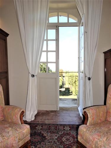 a room with an open door with two chairs at Château MontPlaisir charming b&b in Provence in Valréas