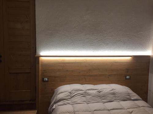 a bed with a light on top of it at Appartamenti De Betta in Sappada