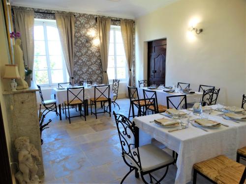 Château MontPlaisir charming b&b in Provence في فالريس: غرفة طعام مع طاولات وكراسي بيضاء